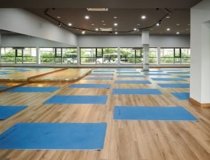 Blue yoga mats rolled out in spacious empty dance studio